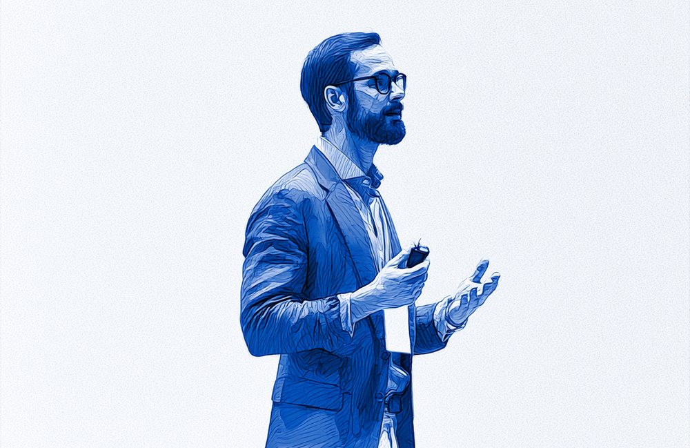 A speaker on stage before a full audience